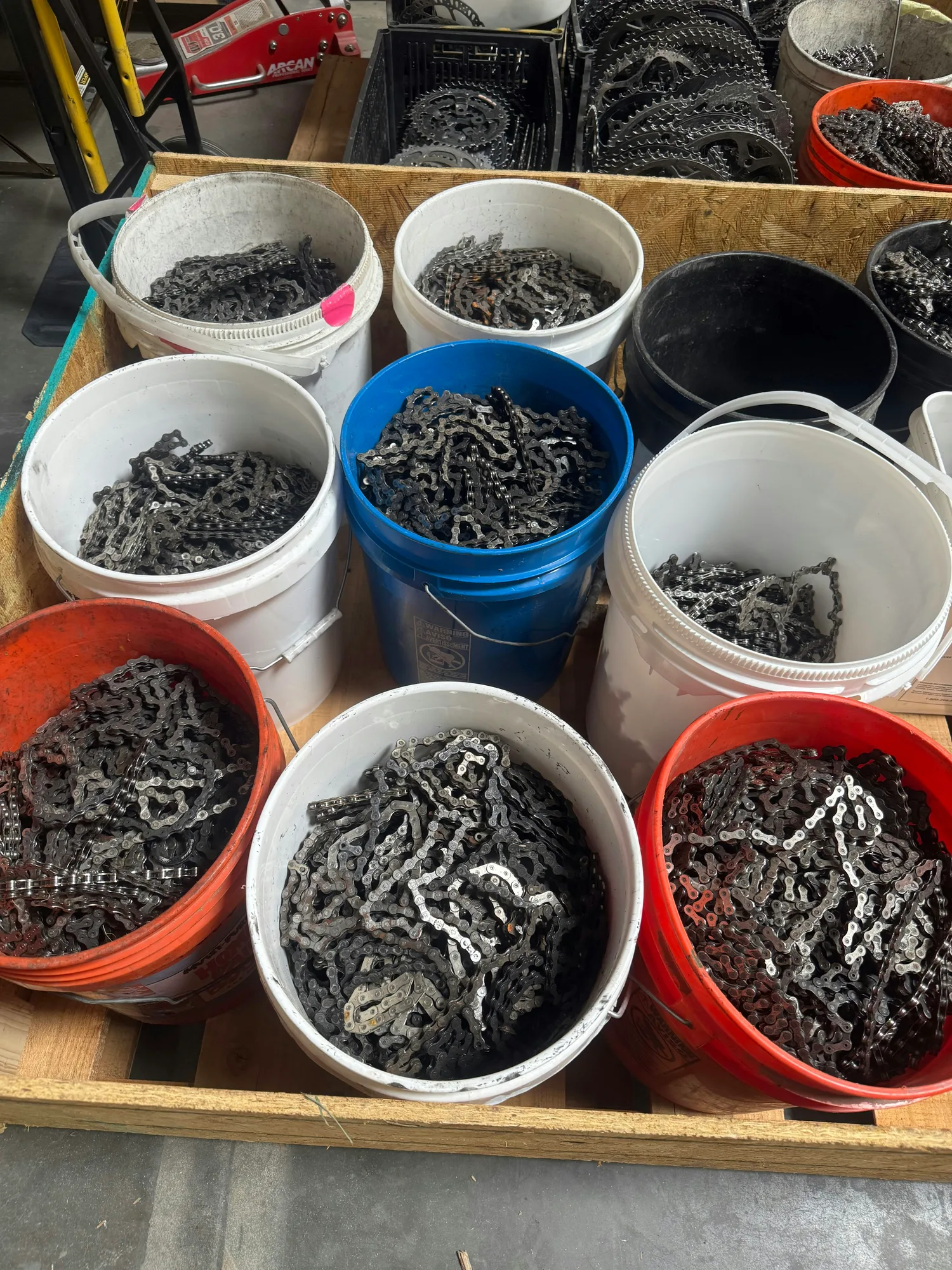 Buckets of donated bike chains sorted for cleaning in the workshop