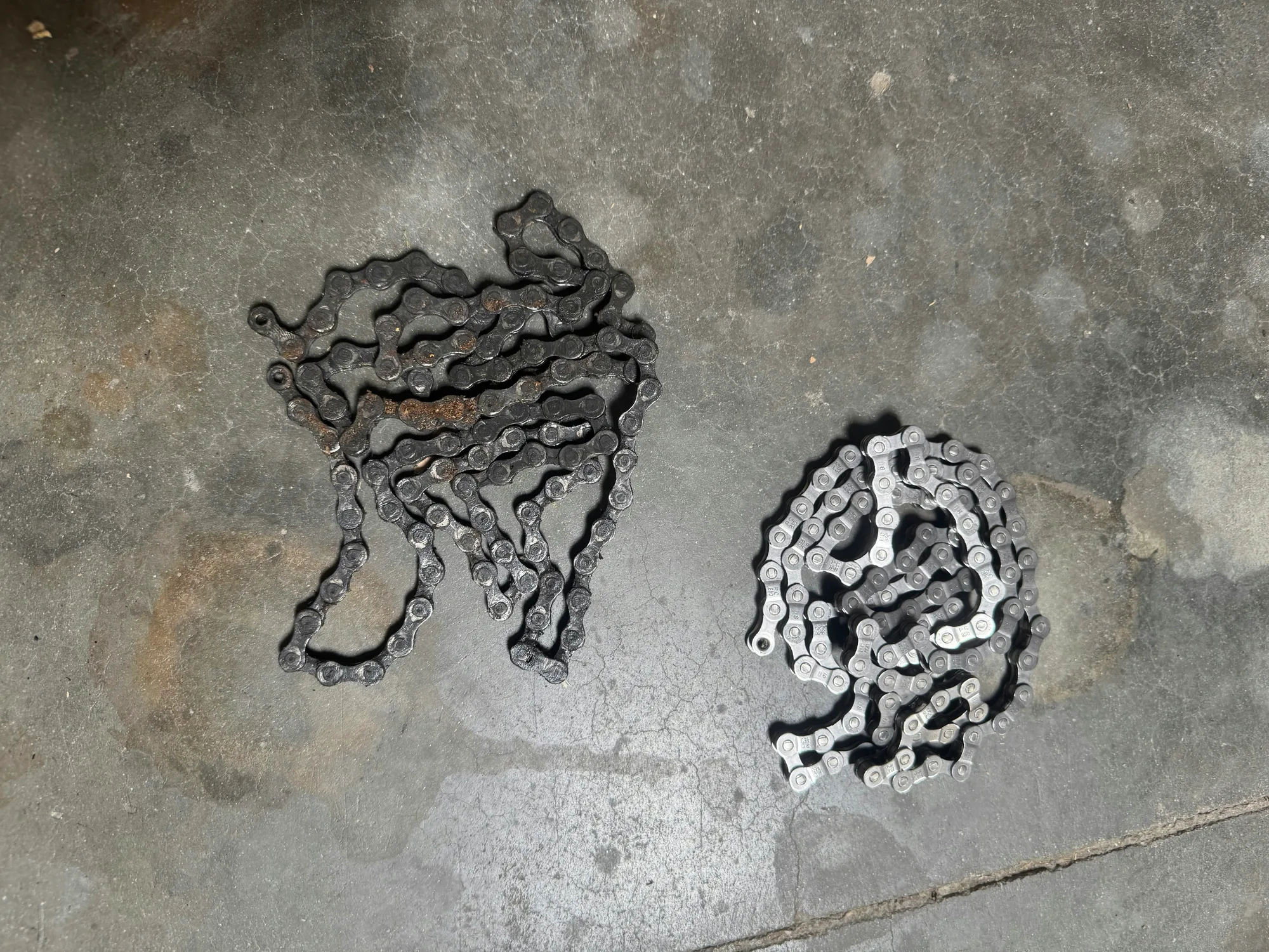 A worn, greasy bike chain beside the same chain cleaned and polished in the ReGeared shop