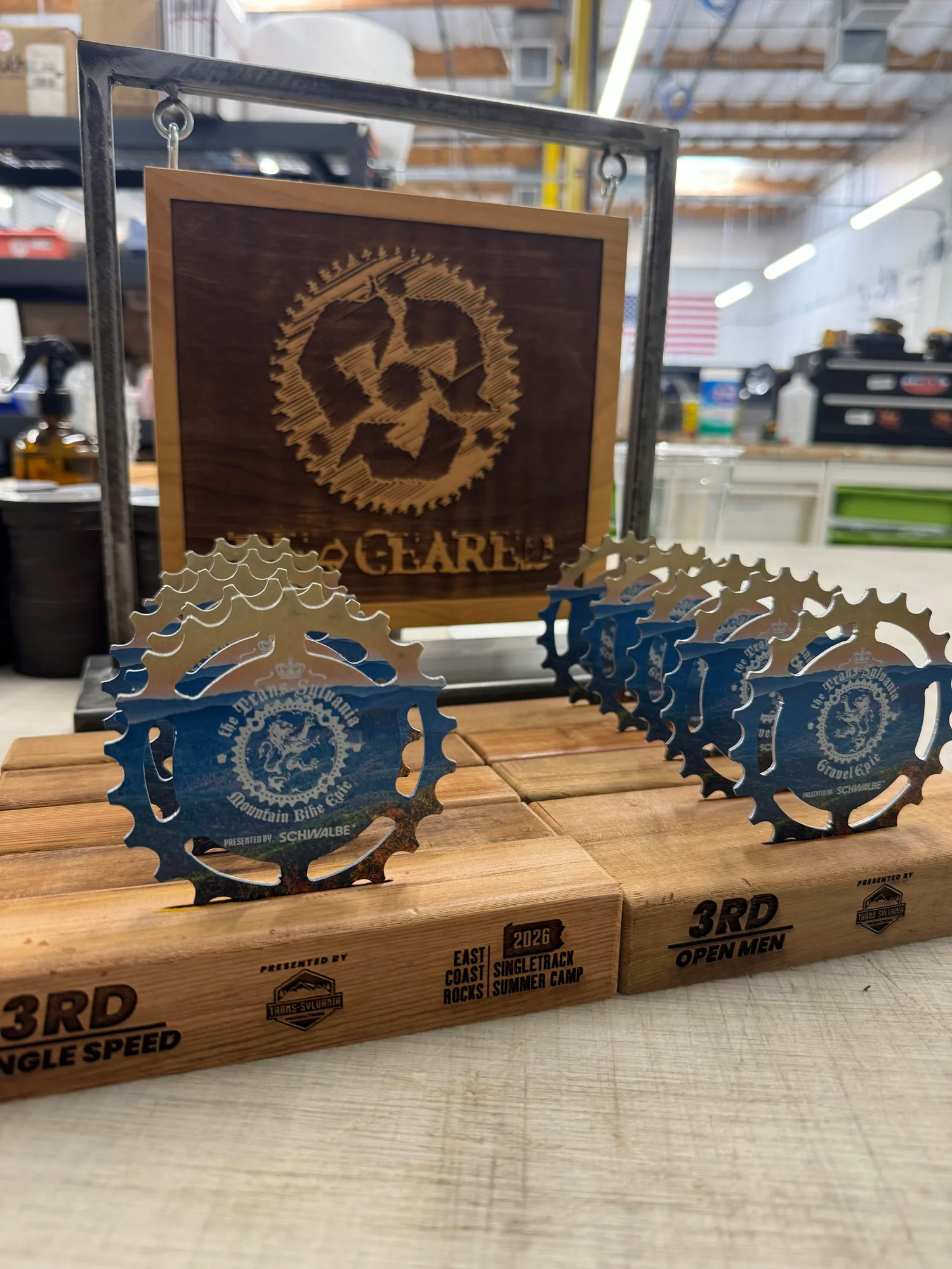Trans-Sylvania Epic series trophies staged in the ReGeared workshop under the shop sign